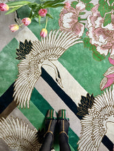 Load image into Gallery viewer, Hand-tufted rug with cranes and pink flowers on a green and pink geometric background, accented with viscose. Measures 6' x 9'